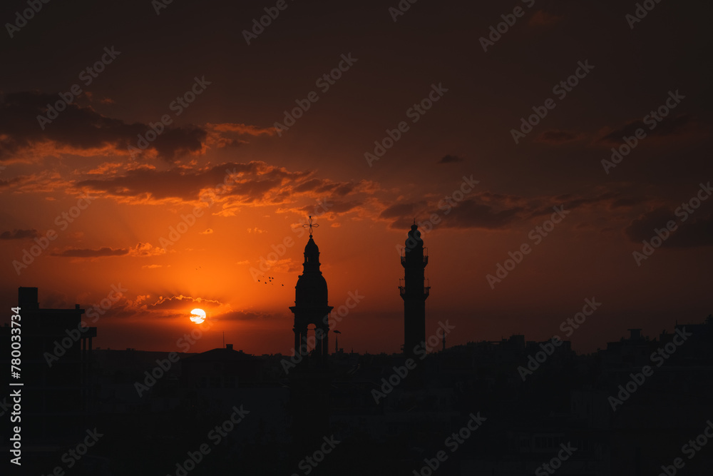 Fototapeta premium church and mosque lives together in midyat view at sunset