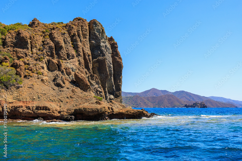 Rocky coast in the resort part of the Mediterranean or Aegean Sea. Background with selective focus and copy space