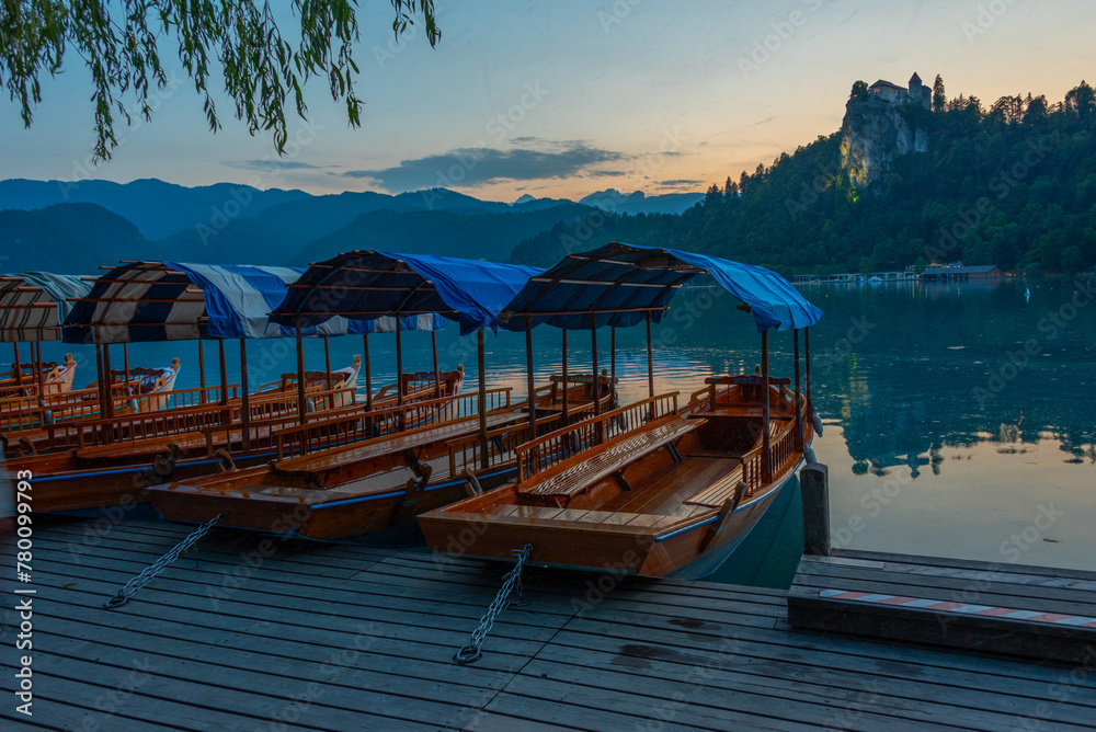 Sunset view over rowing boats looking at Bled castle in Slovenia