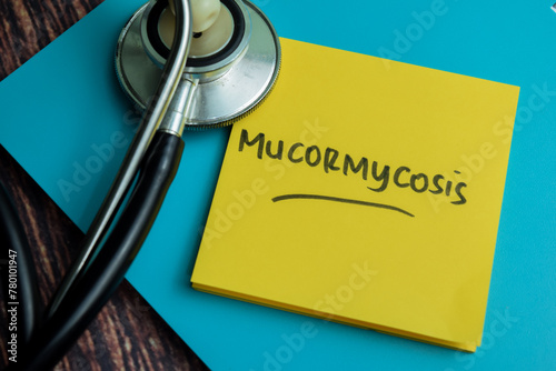 Concept of Mucormycosis write on sticky notes isolated on Wooden Table. photo