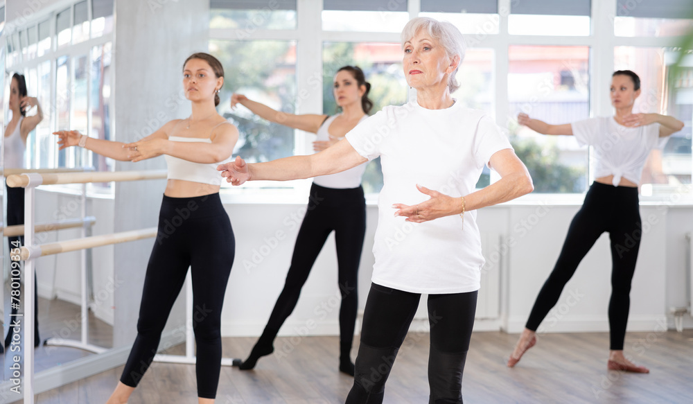 Fototapeta premium Group of women perform ballet moves in dance class