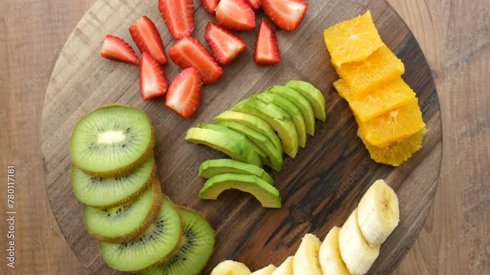 Close-up top view of fruits on a rotating wooden plate.