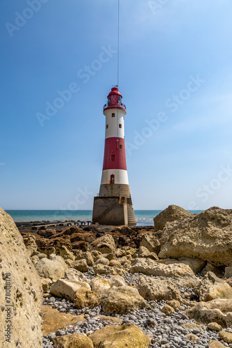 A view of Beachy Head lighthouse on the Sussex coast, with a blue sky overhead