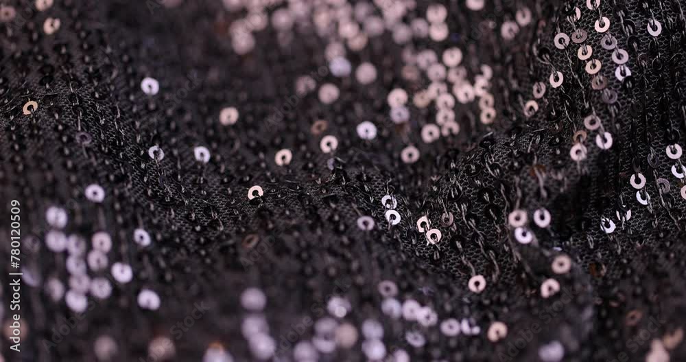 a large number of sequins on a black material, a part of the black material decorated with plastic discs to create shine a large number of sequins on a black material, a part of the black material decorated with plastic discs to create shine