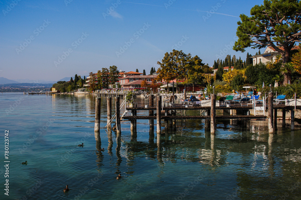  City of Sirmione on Lake Garda, wooden pier with built-up lake shore, Italy, Europe.
