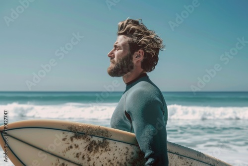 Man on the beach holding a surfboard, leisure and hobby concept.