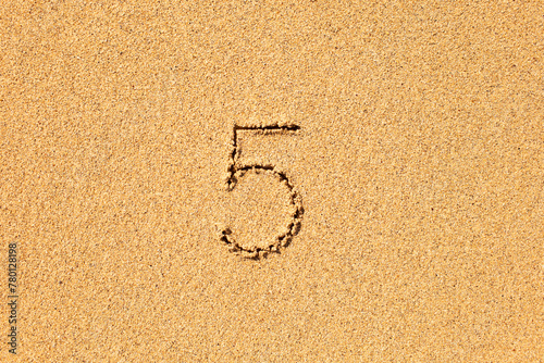 Number five 5 inscription written in the sand 