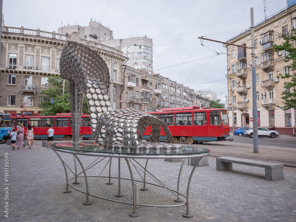 tram running behind the high-heeled shoes shaped art object on the street in dnipro  city