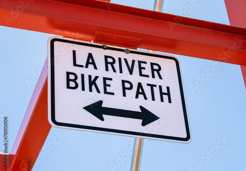 LA River Bike Path sign on metal bridge structure with two way arrow.  