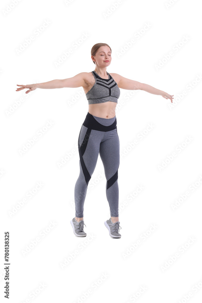 Sporty young woman balancing on white background