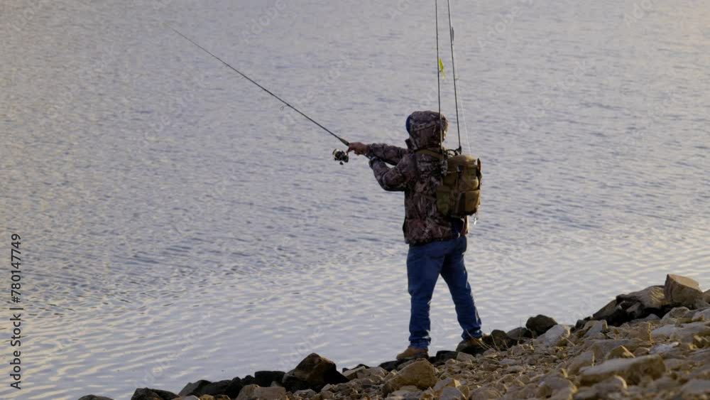 UNRECOGNIZABLE MAN FISHING FROM THE SHORELINE. SHOT IN 4K, FULL FRAME, 10 BIT, LOG UNRECOGNIZABLE MAN FISHING FROM THE SHORELINE. SHOT IN 4K, FULL FRAME, 10 BIT, LOG