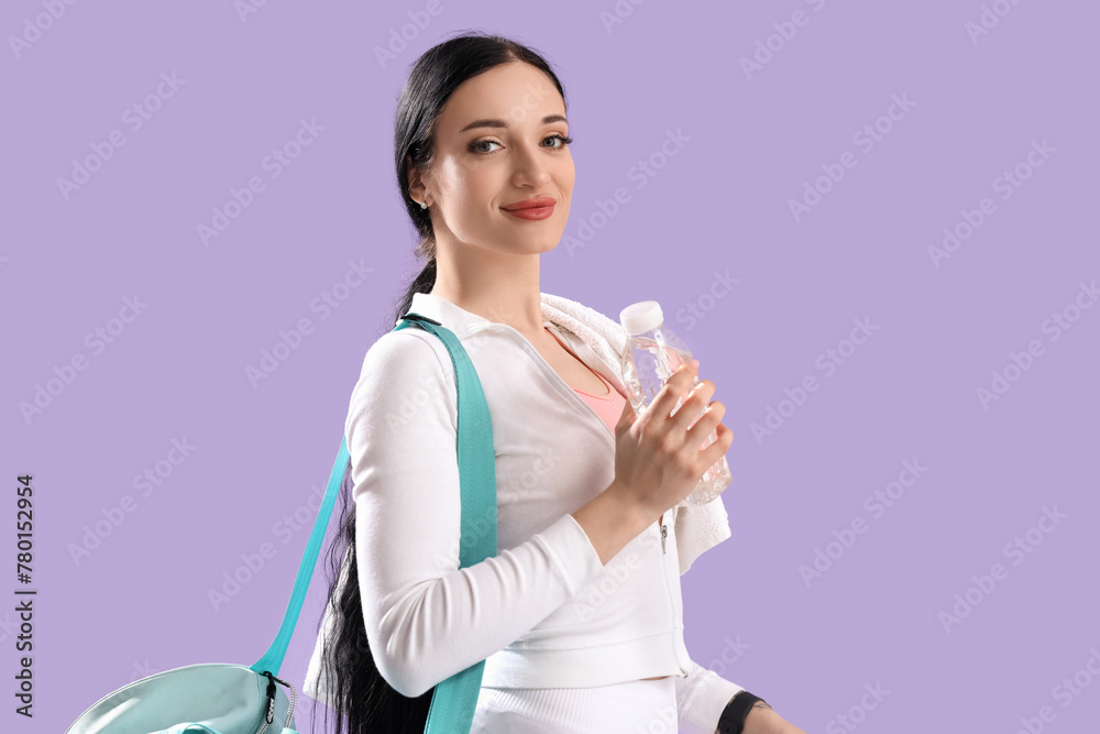 Portrait of sporty young woman with bottle of water and sport bag on lilac background Portrait of sporty young woman with bottle of water and sport bag on lilac background