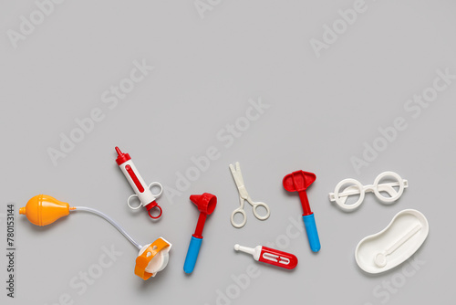 Toy first aid kit with glasses and scissors on grey background. Top view