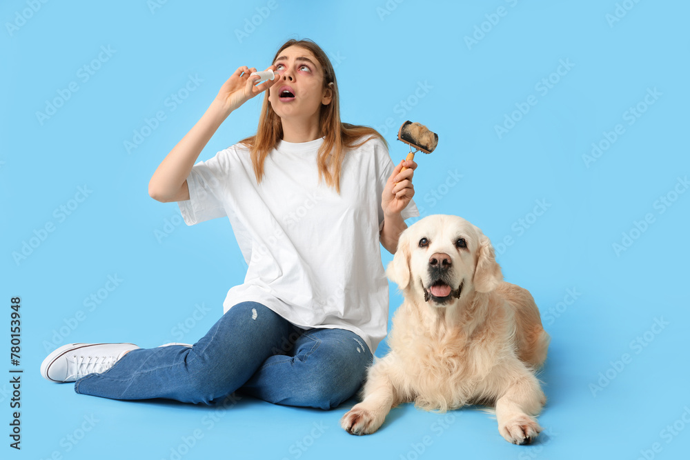 Young woman suffering from pet allergy with labrador dog on blue background