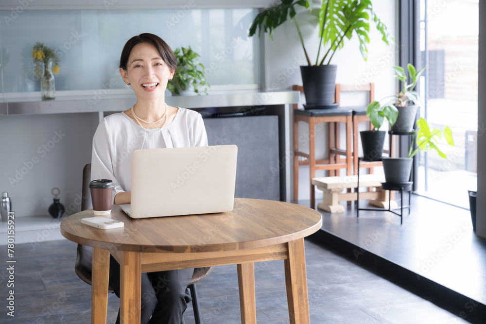 綺麗なオフィスやカフェでノートパソコンを使いッ仕事をする女性 カメラ目線 右にコピースペースあり 綺麗なオフィスやカフェでノートパソコンを使いッ仕事をする女性 カメラ目線 右にコピースペースあり
