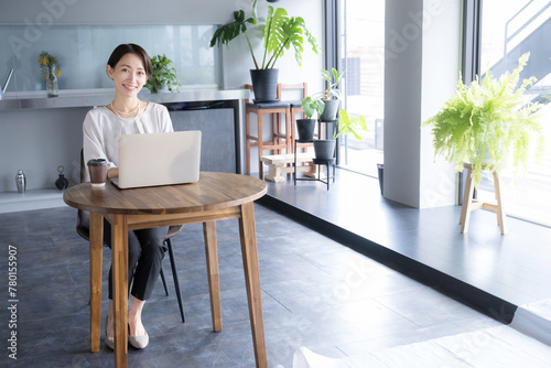 Woman working with laptop computer in beautiful office or cafe Full body looking at camera