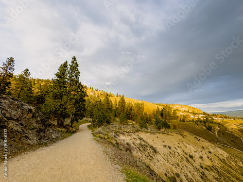 Dirt road on a mountain with partially overcast sky at sunset 