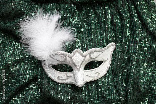 White carnival mask with feathers on bright green background