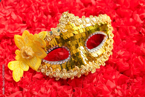 Fototapeta Naklejka Na Ścianę i Meble -  Golden carnival mask with flower on red texture background