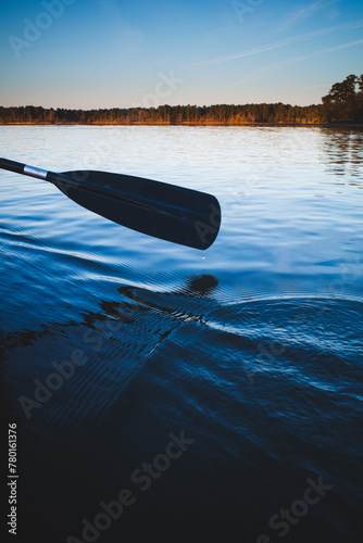 A paddle dips into calm waters during an evening paddle on Falls Lake, near Durham, North Carolina