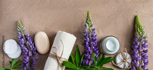 Natural organic cosmetics and lupine flowers on craft paper background.