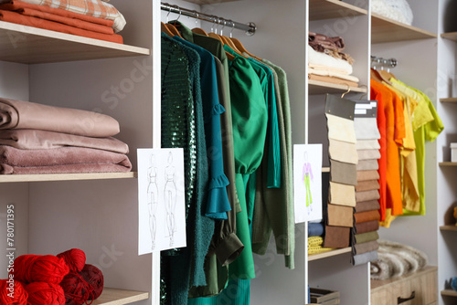 Shelves with clothes and sketches in atelier photo
