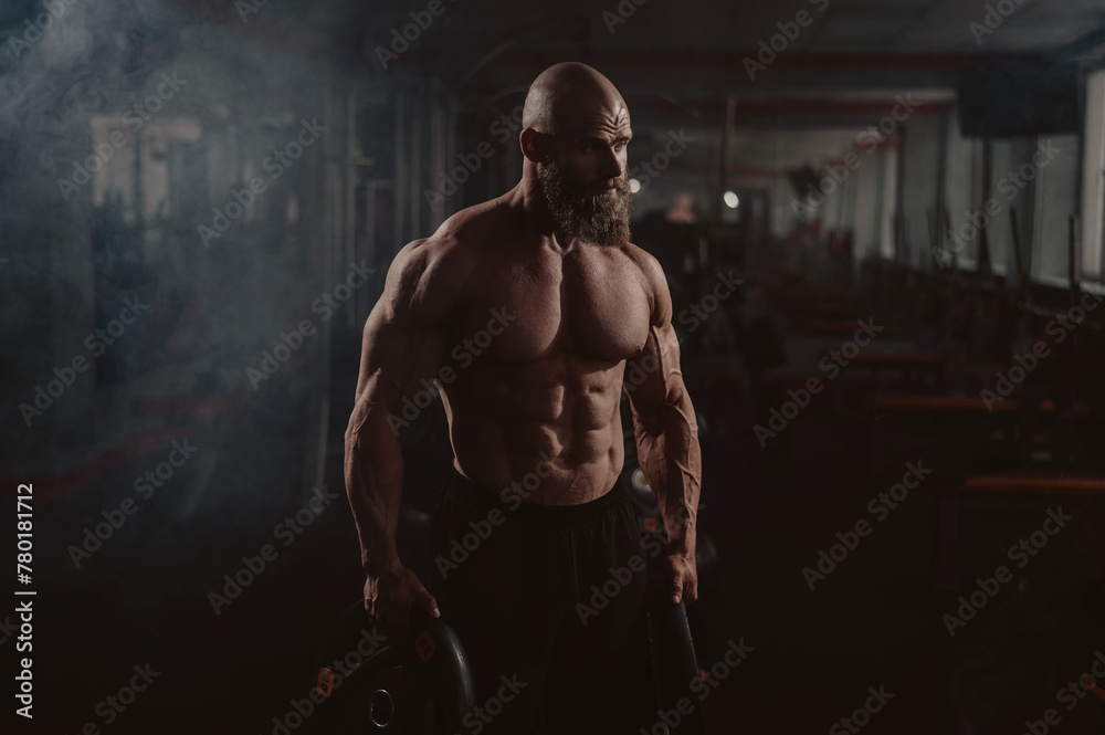 Fototapeta premium Caucasian bald man posing in the gym.