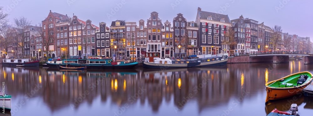 Panorama of Amsterdam canal Singel and dutch houses during morning blue hour, Holland, Netherlands.