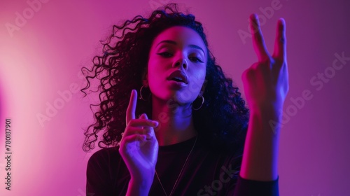 Young woman giving a peace sign gesture with vibrant neon lighting.