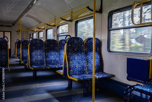 Selective blur on empty Row of seats in refurbrshed latvian regional train with aisle, with nobody russian style on travel in Latvia belonging to Latvian railways with speed blur through the windows. photo