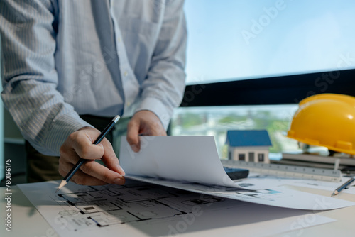 engineer is working in a modern office in the building of the engineering design company, an architect is checking on document of an important project, engineer use various tools to help work easier.