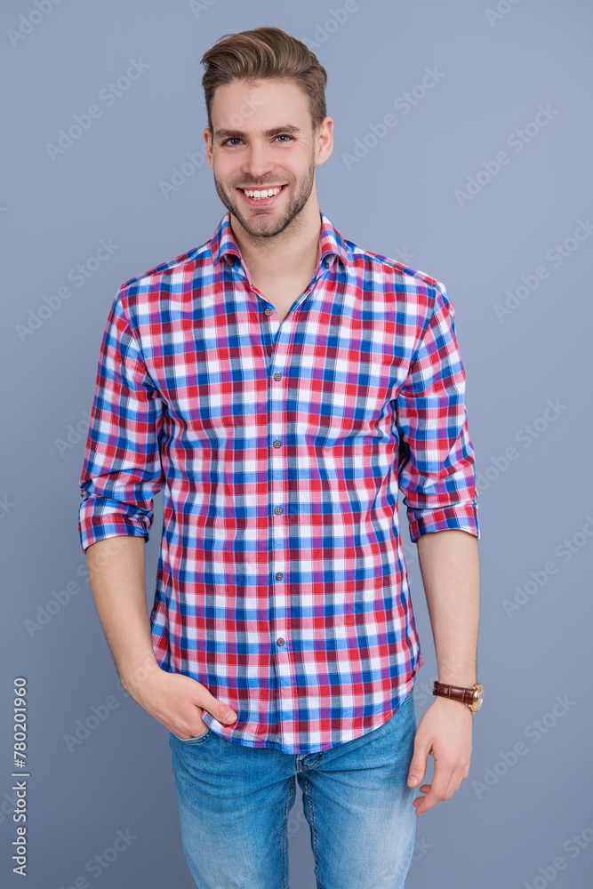 Man in checkered shirt isolated on grey. Handsome young man with hairstyle. Trendy male fashion. Male casual style. Skin care and men beauty concept. Caucasian millennial guy. Happy youth