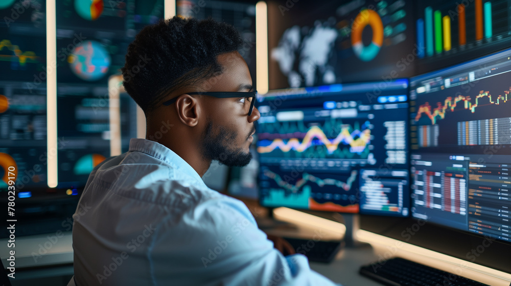 Data analyst, accountant, business owner, financial works with data, graphs behind monitors Data analyst, accountant, business owner, financial works with data, graphs behind monitors