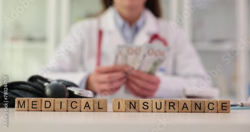 Female doctor counts money and word health insurance photo
