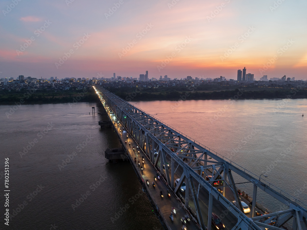 Obraz premium Aerial view of Chuong Duong bridge crossing Red River in Hanoi at sunset