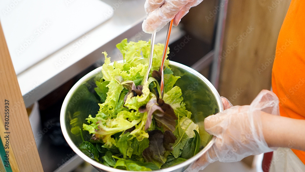 Person Holding Bowl of Salad With Gloves