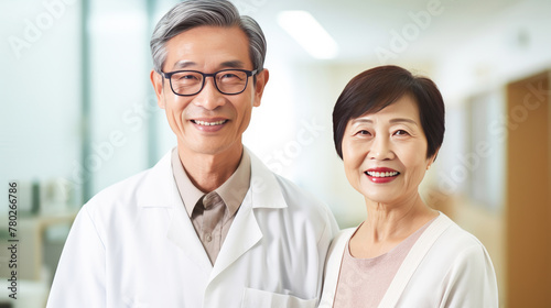 Portrait of a smiling elderly Asian Korean doctor man with a stethoscope in a medical hospital with modern equipment.