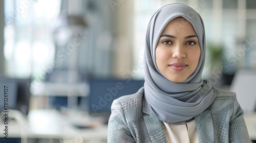 Confident woman in hijab as a professional data analyst smiling in a modern office setting © Superhero Woozie