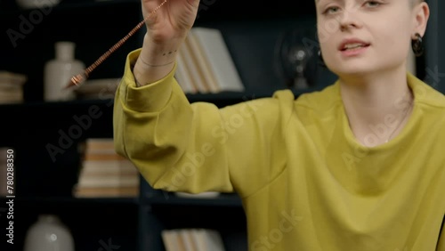 Close-up of female psychologist hypnotizing patient using pendulum, to create state of focused attention and increased suggestibility in treatment of psychological disorder at office. photo