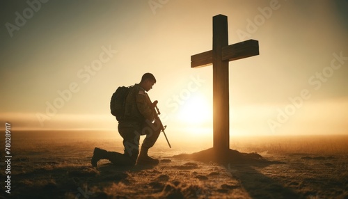 A solitary soldier in contemporary military uniform kneeling before a large wooden cross at sunrise, with the sunlight casting a warm and peaceful. photo