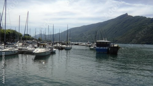 Motorboats docked at Aix Les Bains France Time Lapse Dent du Chat mountain background, calm water scenario, Lake Bourget in the Savoie, eastern France photo