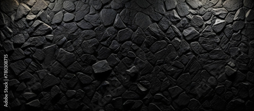 A stone wall stands starkly against a black background, showcasing its rugged texture and solidity photo