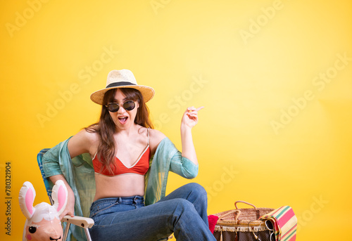 Excited Young Latina Pointing and Laughing on Yellow Background