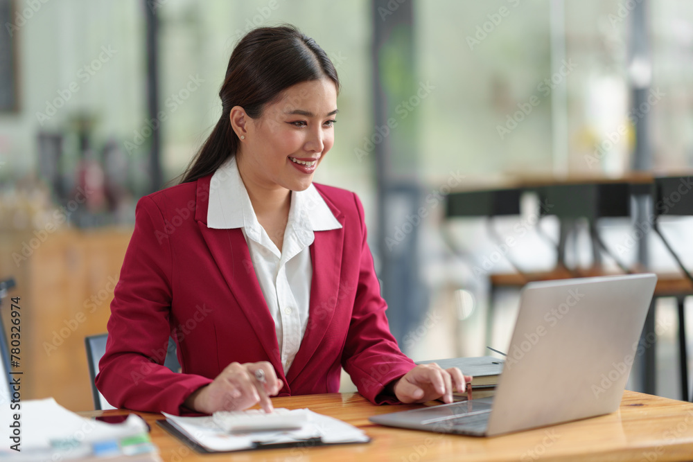 Businesswoman working with online data on laptop and folders Stack of documents to analyze, plan, and calculate financial statistics, and taxes at a desk in a modern office. Businesswoman working with online data on laptop and folders Stack of documents to analyze, plan, and calculate financial statistics, and taxes at a desk in a modern office.