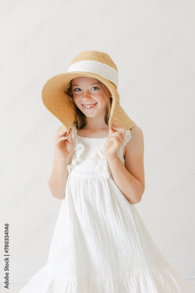 young girl wearing white dress and oversized hat young girl wearing white dress and oversized hat