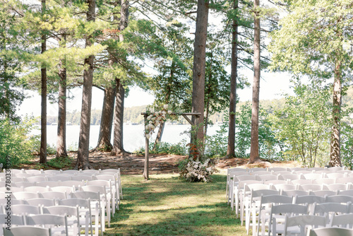 Lakeside wedding ceremony setup with floral arch