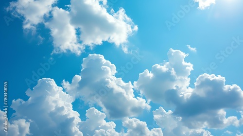 Blue sky and white clouds. The sun is shining through the clouds. The sky is clear and bright. The clouds are fluffy and white.