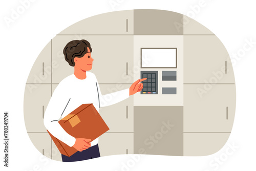 Man uses self-service postal kiosk to send parcel or temporarily store it in terminal. Guy with box in hands enters password on dial electronic postal kiosk to transfer box to courier delivery service