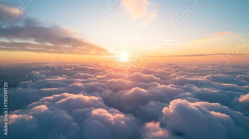 Amazing view above the clouds at sunset. The soft colors of the sky and the clouds create a beautiful and peaceful scene.