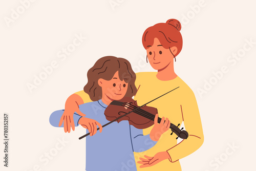 Learning to play violin for teenage girl, from professional teacher who helps to hold bow correctly. Caring mother teaches daughter to perform music on violin, practicing before concert with audience